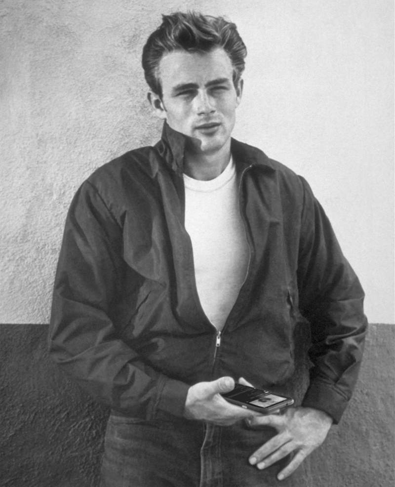 James Dean - a classic icon of coolness - leaning back against a wall. His eyes squint uncaring towards the camera. His hands lie by his waist, and the image has been edited so one of his hands is holding a mobile phone.