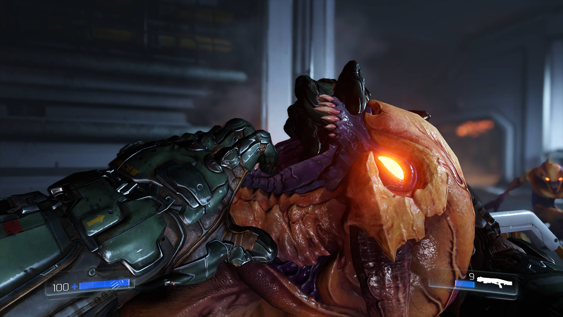 A screenshot from Doom (2016) showing off a 'glory kill'. The player holds an enemy Imp's jaws open, ready to snap their head apart